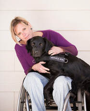 Woman in wheelchair with service dog on her lap