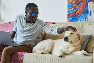 Man sitting on couch with service dog